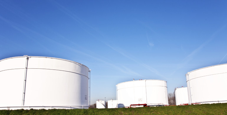 white tanks in tank farm with blue clear sky